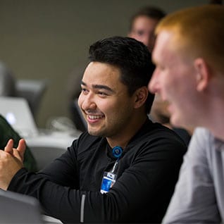 Student sitting in class smiling.